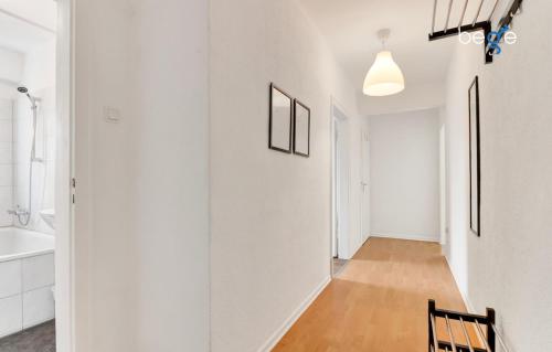 pasillo con paredes blancas, mesa y silla en BEGE APARTMENTS WorkAway Residence, en Bochum