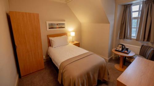 a hotel room with a bed and a table and a window at The Tarbet Hotel in Tarbet