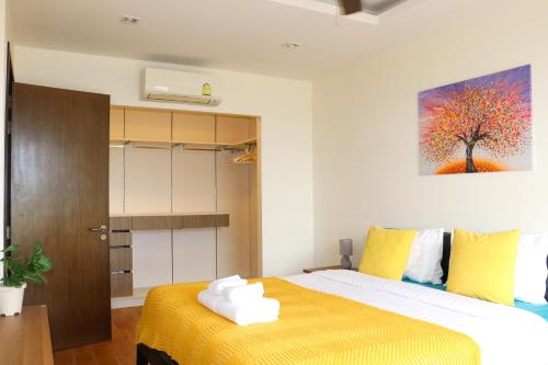 - une chambre avec un lit et une peinture murale dans l'établissement Lovely Townhouse in Laguna Park, à Thalang