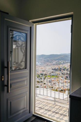 an open door with a view of a city at Aurora Syros Apartment in Ano Syros
