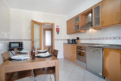 a kitchen with a wooden table and a dining room at Ferrel Casual Home - Baleal in Ferrel
