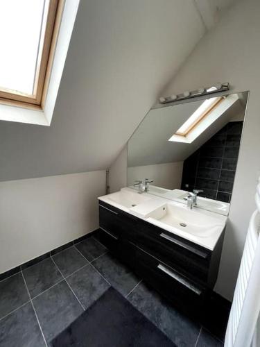 une salle de bain avec un lavabo et un miroir dans l'établissement Maison familiale, idéale JO 2024, à Colombes