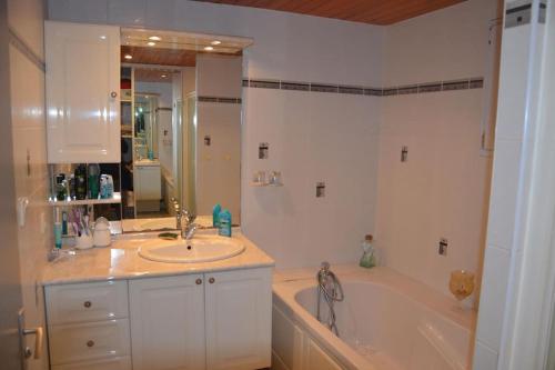 a bathroom with a sink and a bath tub at Maison à la campagne avec piscine 12 pers in Genouillé