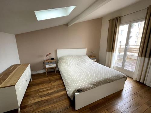 une chambre avec un lit et une grande fenêtre dans l'établissement Maison familiale, idéale JO 2024, à Colombes