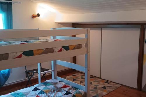 a bunk bed in a small room with a bunk bedutenewayangering at Maison à la campagne avec piscine 12 pers in Genouillé