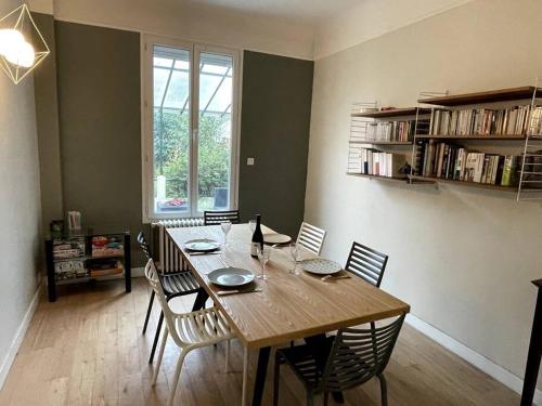 une salle à manger avec une table et des chaises en bois dans l'établissement Maison familiale, idéale JO 2024, à Colombes