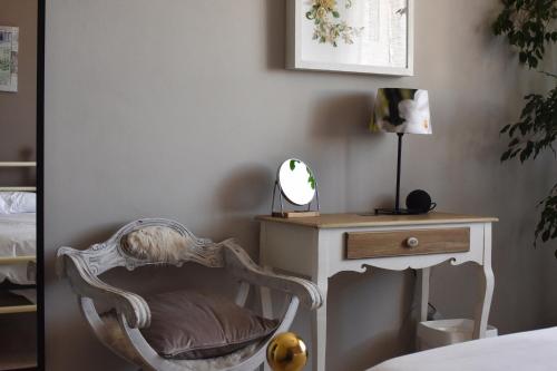 a bedroom with a chair and a desk with a mirror at The Piedmont Gate in Collegno