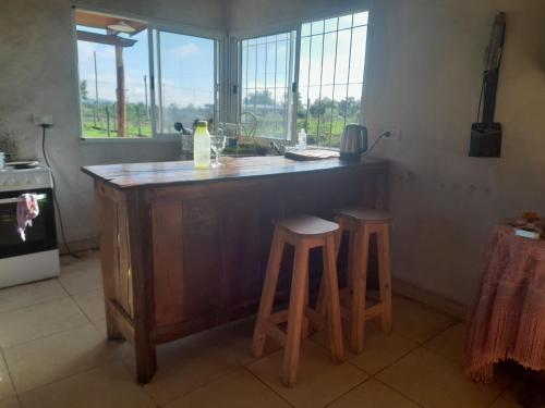 a kitchen with a wooden counter and two stools at La rosa in Salta
