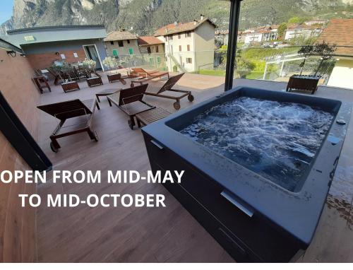 una grande vasca idromassaggio su un patio con sedie di Garda Family & Solarium a Riva del Garda