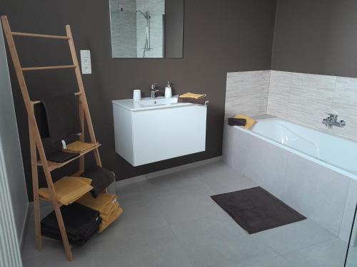 a bathroom with a white sink and a bath tub at Chez Jeannine et Yvo in Mai Cornet