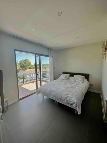 a bedroom with a bed and a large window at Villa in Sainte-Eulalie