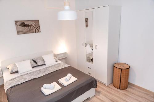 um quarto branco com uma cama grande e 2 toalhas em Apartman Murter 2+1 em Murter