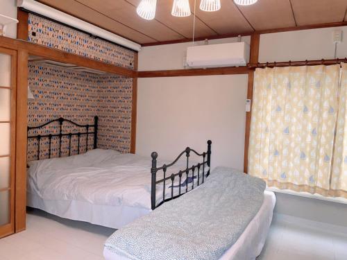 um quarto com 2 camas e uma parede de tijolos em 世田谷 大晶家 direct to Shinjuku for 13min 上北沢3分 近涉谷新宿 em Tóquio