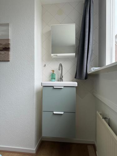 a bathroom with a sink and a mirror at Guesthouse West in Noordwijk