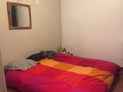 a bed with a colorful blanket on top of it at Agréable maison de ville avec parking gratuit in Montpellier