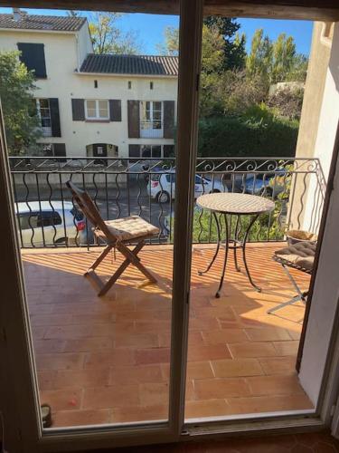 Elle offre une vue sur une terrasse dotée d'une table et d'une chaise. dans l'établissement Agréable Maison 4 chambres wifi et parking gratuit, à Montpellier