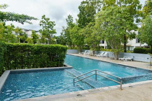 - une piscine dans un bâtiment arboré dans l'établissement Lovely Townhouse in Laguna Park, à Thalang