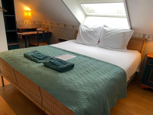 a bedroom with a bed with two towels on it at B&B Agnes in Vlissegem