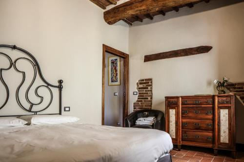 una camera da letto con un letto e una cassettiera in legno di IL MAGNIFICO a Montepulciano
