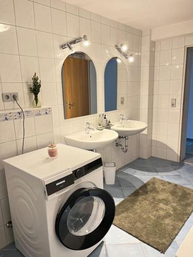a bathroom with a washing machine and a sink at Deluxe Apartment Ella in Backnang