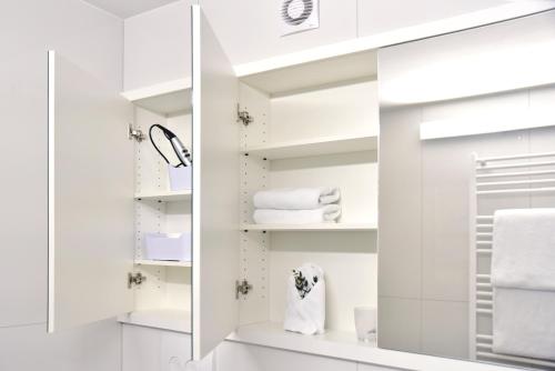 ein Badezimmer mit weißen Handtüchern und einem Spiegel in der Unterkunft Top Wohnung in Refrath bei Köln in Bergisch Gladbach