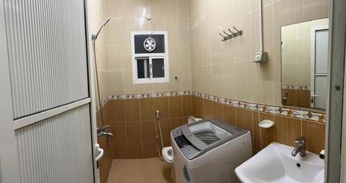 uma pequena casa de banho com WC e lavatório em Al Manafa Furnished Apartments em Salalah