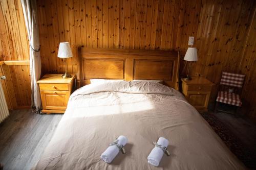 ein Schlafzimmer mit einem Bett mit zwei weißen Handtüchern darauf in der Unterkunft Hôtel-Restaurant Le Berger Blancc in Evolène