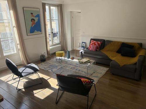 un salon avec un canapé et des chaises dans l'établissement South Pigalle - 2 bedrooms luxury flat, à Paris
