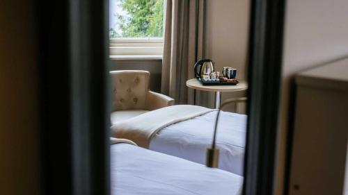 a room with a chair and a table and a window at The Tarbet Hotel in Tarbet