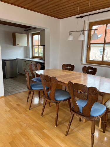 a dining room with a wooden table and chairs at Ferienplatzl 90m2 in Peißenberg