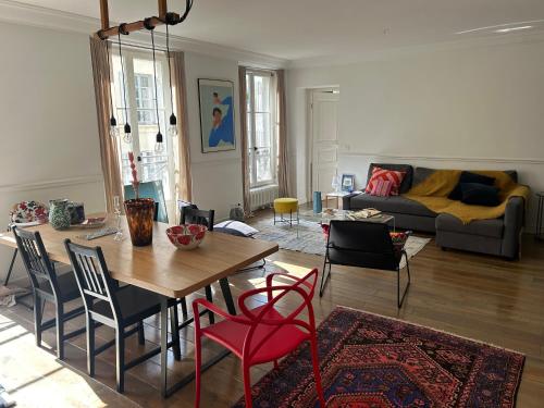 un salon avec une table, des chaises et un canapé dans l'établissement South Pigalle - 2 bedrooms luxury flat, à Paris