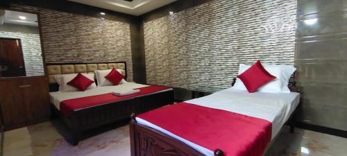 1 dormitorio con 2 camas y almohadas rojas en Supreme Hotels 2.0, en Warangal
