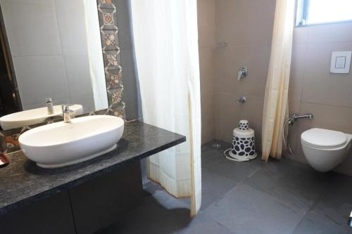 a bathroom with a white sink and a toilet at HSM Grand Inn, Chittoor in Chittoor