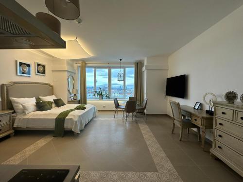 a bedroom with a bed and a desk and a table with chairs at Panorama Apartments Vienna in Vienna
