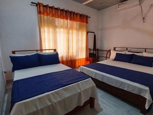 1 dormitorio con 2 camas y ventana en kithulgala Green Rafting Hotel en Kitulgala