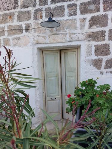 una porta in un edificio in pietra con fiori e piante di la chiesetta a Nardò