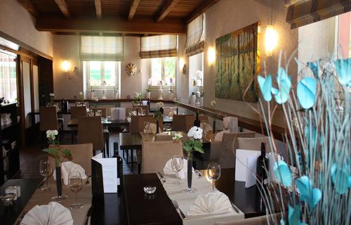 a dining room with tables and chairs in a restaurant at Auberge Bleech in Larochette