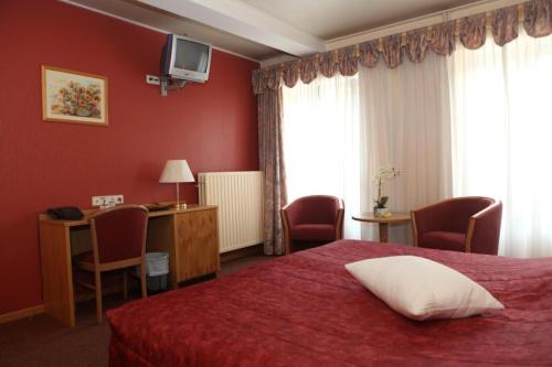 Auberge Bleech في لاروشيتا: غرفة في الفندق بها سرير ومكتب ونافذة