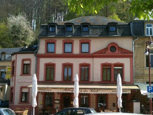 a building with white umbrellas in front of it at Auberge Bleech in Larochette