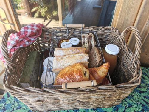a basket filled with bread and pastries on a table at La bulle des champs in Champmotteux