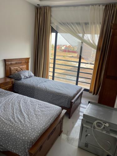 um quarto com 2 camas e uma grande janela em Nador Apartment em Nador