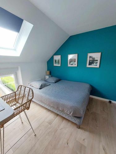- une chambre avec un lit et un mur bleu dans l'établissement Escale à Épernay: Studio proche du centre ville, à Épernay