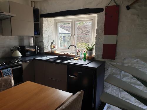 a kitchen with a sink and a window at Kingfisher Cottage in High Bentham