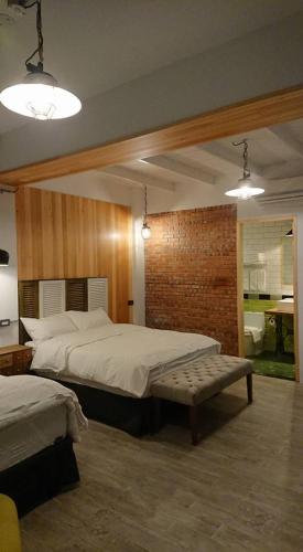 a bedroom with a large bed and a bench at Mr. Buster B&B in Hualien City