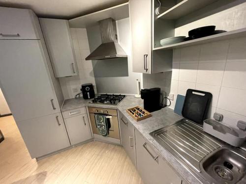 a small kitchen with a stove and a sink at Aberdeen Beach 2 Bed Apartment in Aberdeen
