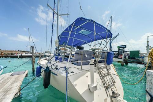 a boat is docked at a dock in the water at Walk barefoot to beach! Private Sailboat at North End, queen bed, en-suite bath, AC in Isla Mujeres