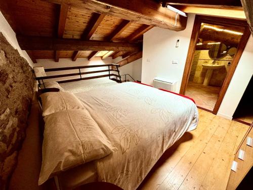 a bedroom with a large bed with a wooden floor at Agriturismo Cervano in Toscolano Maderno