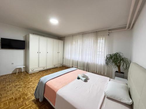 a bedroom with a large bed and a tv at Avlija Garden Gem in Sarajevo