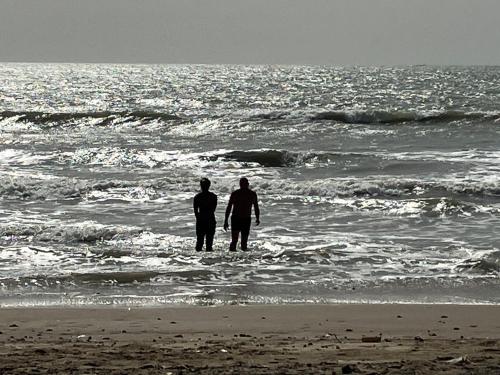 two people standing in the water at the beach at Poco Loco B&B in Abene