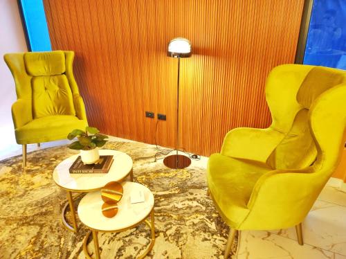 two yellow chairs and a table in a room at Republica del Salvador Coliving Ecuador XOE in Quito